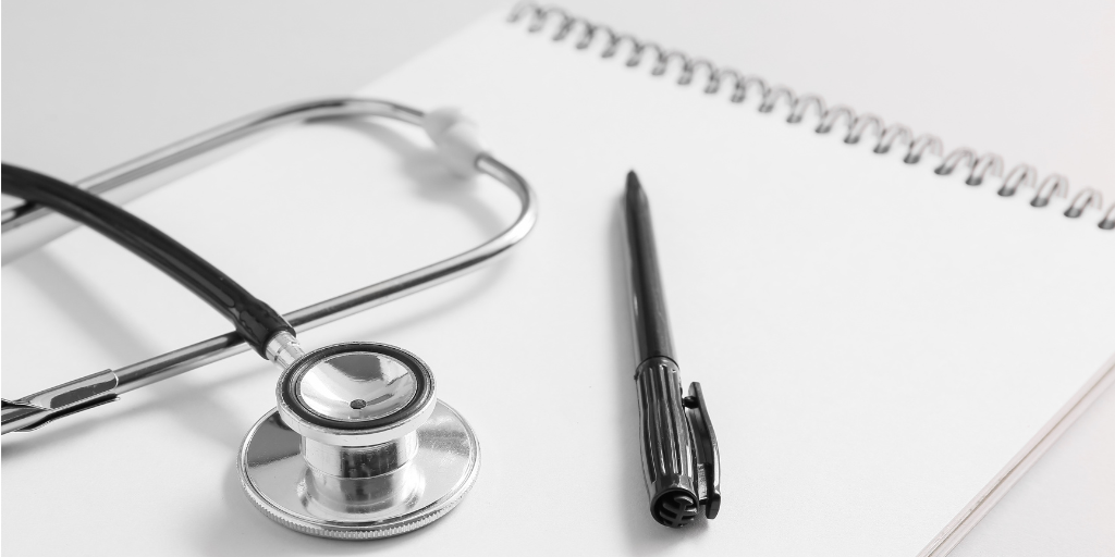 Stethoscope, pen and paper